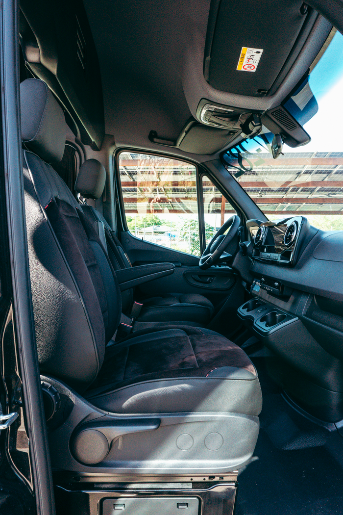 Services Spacious interior of a luxury black executive van with comfortable seating.